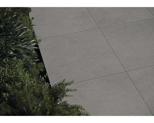 Dalles de terrasse posées à côté de plantes vertes.