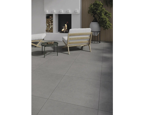 Espace de vie avec carrelage, cheminée, fauteuil et table d''appoint