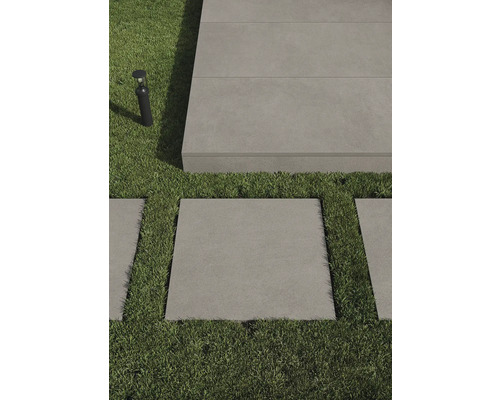 Aménagement de jardin avec pelouse, plaques de pierre et luminaire extérieur