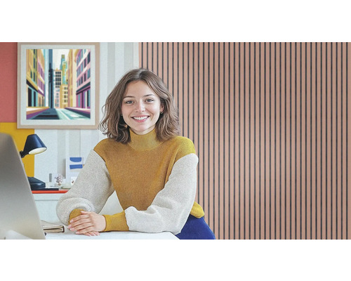 Femme assise à un bureau devant un mur de panneaux acoustiques dans un bureau