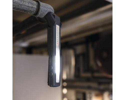 Scangrip Logo. Arbeitsleuchte mit Magnet und LED-Licht hängt an einem Rohr.
