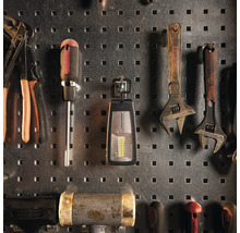 Werkzeuge wie Schraubenschlüssel, Schraubendreher und Zangen an einer Werkzeugwand