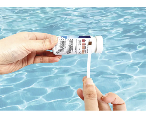 Une personne teste la salinité d''une piscine avec une bandelette de test