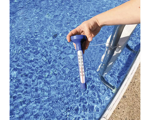 Hand hält Poolthermometer ins Wasser