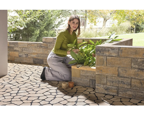 Femme travaille dans le jardin avec des pierres à planter et des dalles de sol