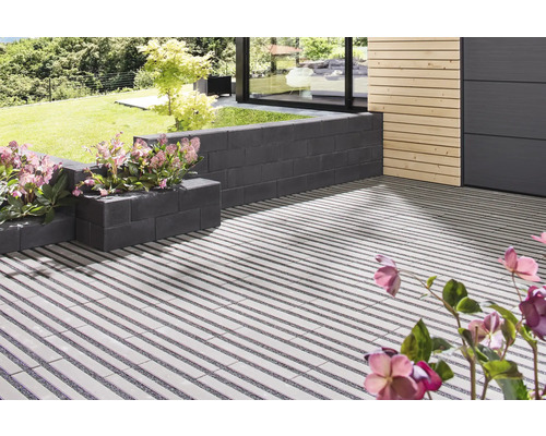 Terrasse mit Pflanzsteinen und linearem Pflasterdesign im Garten