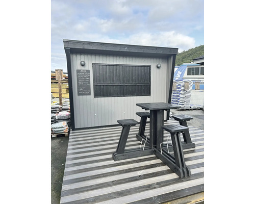 Stand de vente avec table en bois et tabourets sur une terrasse en bois