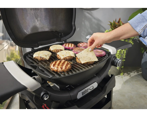 Weber Grill mit Burgern und Käse belegt
