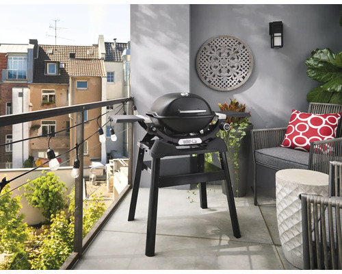 Weber Grill auf einem Balkon mit Sitzgelegenheit und Dekorationen