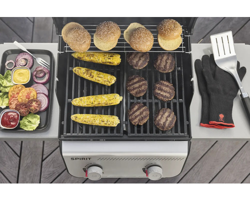 Grill mit Burgern, Maiskolben, Burgerbrötchen, Grillhandschuhen, Grillwender und Zutaten