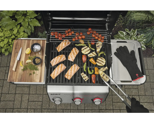 Barbecue à gaz avec saumon, légumes et gants de barbecue