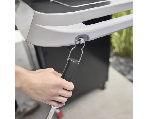 Gros plan d''une pince à barbecue fixée à un barbecue