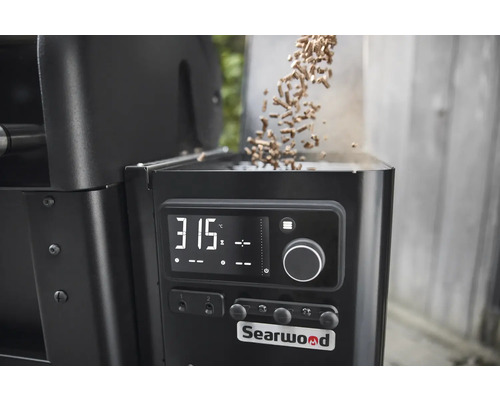Detailansicht eines Searwood Pelletgrills mit digitaler Temperaturanzeige und Holzpellets, die eingefüllt werden