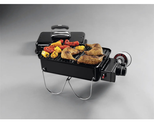Tragbarer Gasgrill mit Grillgut.