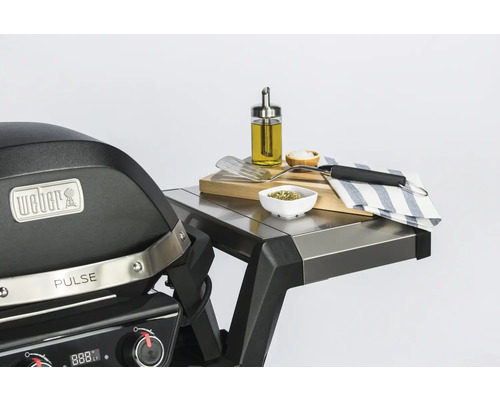 Weber Pulse Elektrogrill mit Zubehör auf einem Edelstahltisch