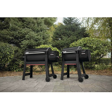 Zwei Weber Pelletgrills im Aussenbereich vor Bäumen und Sträuchern.