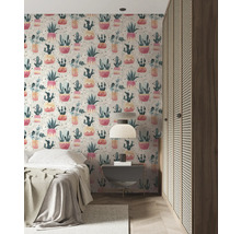 Schlafzimmer mit gemusterter Tapete mit Kakteenmotiven, Nachttisch, Bett und Kleiderschrank.