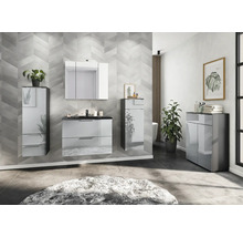 Modernes Badezimmer mit Waschbeckenunterschrank, Spiegelschrank und Hochschrank vor einer gemusterten Wand.