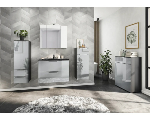 Salle de bains moderne avec meuble sous-lavabo, armoire de toilette à miroir et armoire haute devant un mur à motifs.