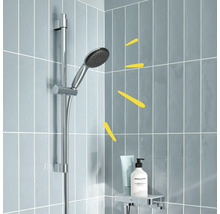 Duschkopf an Duschstange mit Ablage für Badezimmeraccessoires vor grauen Fliesen