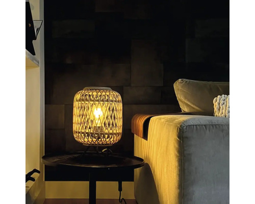 Lampe de table décorative en rotin à côté d''un canapé sur une table