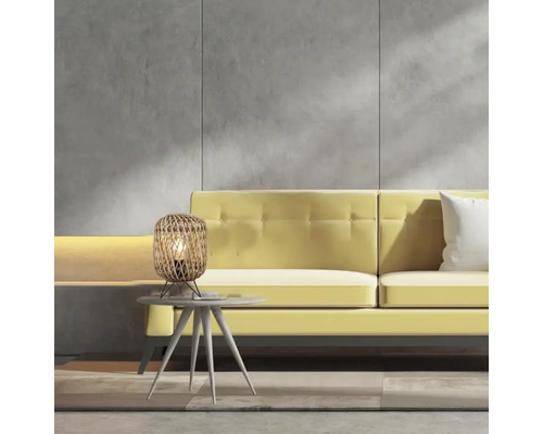 Scène avec lampe de table en rotin sur une table d''appoint devant un canapé jaune.