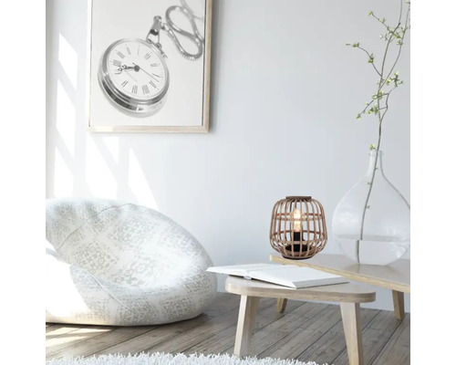 Salon lumineux avec pouf, table, lampe de table et décoration