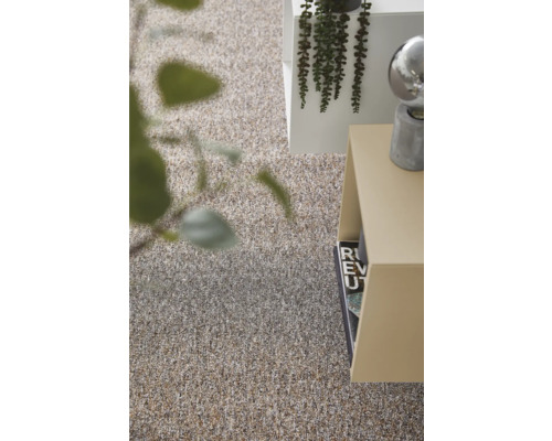 Nahaufnahme eines Teppichs neben einem Beistelltisch und einer Pflanze