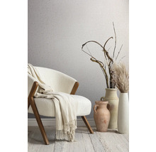 Dekoratives Zimmer mit Stuhl, Decke, Vasen und gemusterter Tapete.