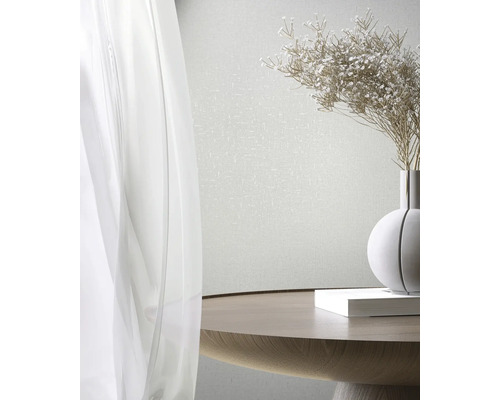 Helle Tapete mit dezenter Struktur hinter einem Tisch mit Blumenvase und Buch.