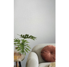 Helles Zimmer mit strukturierten Tapeten, Sofa, Zierkissen und Pflanze im Topf