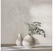 Deux vases et un papier peint à motifs sur une table.