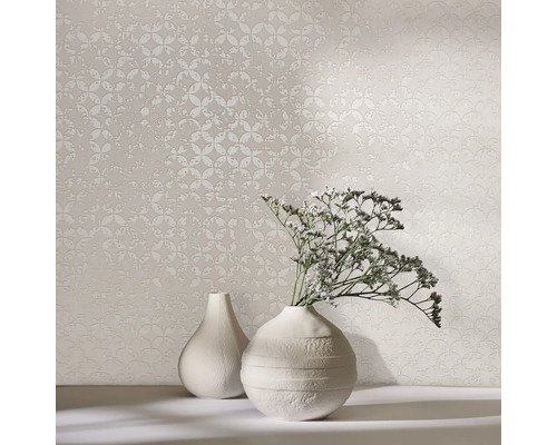 Deux vases et un papier peint à motifs sur une table.