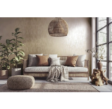 Wohnzimmer mit Rattansofa, Kissen, Teppich und Zimmerpflanzen