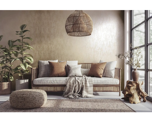 Wohnzimmer mit Rattansofa, Kissen, Teppich und Zimmerpflanzen