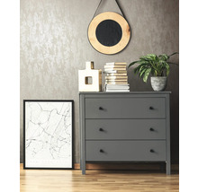 Szene mit grauer Kommode, rundem Spiegel, Pflanze, Büchern und einem gerahmten Bild