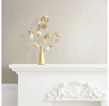 Dekoratives Stillleben mit goldener Vase und Ginkgozweigen auf einem weißen Kaminsims.