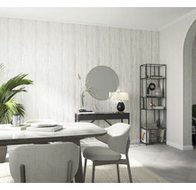 Heller Speiseraum mit Esstisch, Stühlen, Konsole, Spiegel und Bücherregal vor einer gemusterten Tapete.