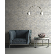 Wohnzimmer mit Sessel, Tisch und gemusterter Tapete