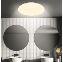 Salle de bains avec miroirs ronds, lavabos et plafonnier rond