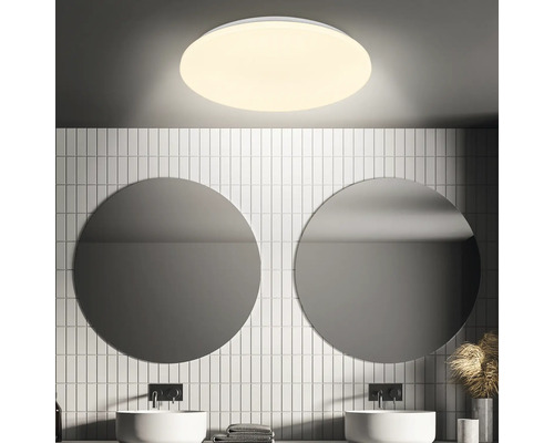 Salle de bains avec miroirs ronds, lavabos et plafonnier rond
