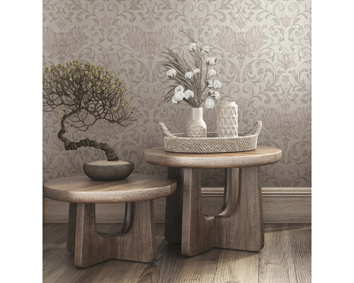 Scène décorative avec deux tabourets en bois, un bonsaï, des vases, des branches de coton et un plateau décoratif devant un papier peint à motifs.