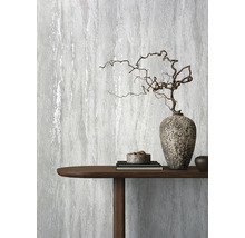 Dekorative graue Tapete mit einem abstrakten Design neben einem Holztisch mit Dekorationen.