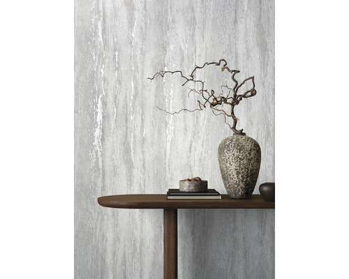 Dekorative graue Tapete mit einem abstrakten Design neben einem Holztisch mit Dekorationen.