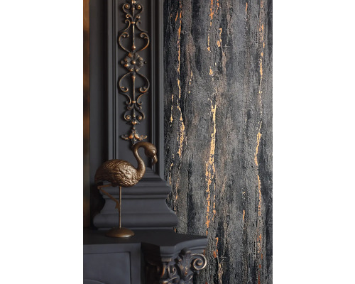 Detailaufnahme einer grauen Wand mit goldfarbenen Akzenten und dekorativen Elementen