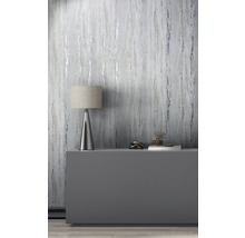 Pièce décorative avec papier peint imitation marbre, lampe de table et objets de décoration sur une commode