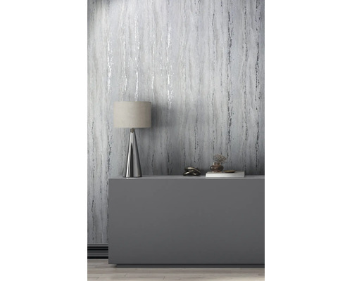 Pièce décorative avec papier peint imitation marbre, lampe de table et objets de décoration sur une commode