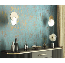 Dekoratives Interieur mit Kommode, Vasen, Diffusor, Zierobjekt und zwei Hängeleuchten vor einer strukturierten Wand