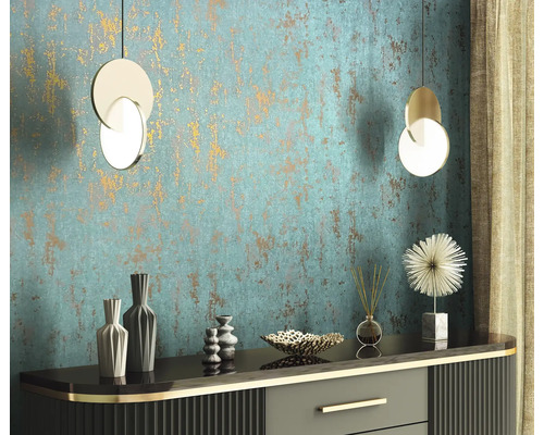 Dekoratives Interieur mit Kommode, Vasen, Diffusor, Zierobjekt und zwei Hängeleuchten vor einer strukturierten Wand