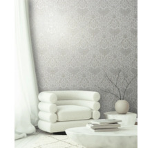 Pièce lumineuse avec papier peint à motifs floraux, fauteuil et table